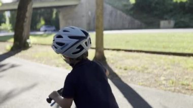 Bisiklet Artırma - Kasklı Çocuk Ağaç Çizgili Kaldırım 'da Bisikleti Hızlandırmak İçin İtti