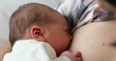 Mother breastfeeding infant newborn baby