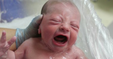 Newborn baby crying taking bath