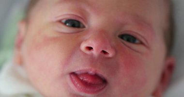 Newborn baby infant first day of life after birth looking, learning, and observing the world for first time