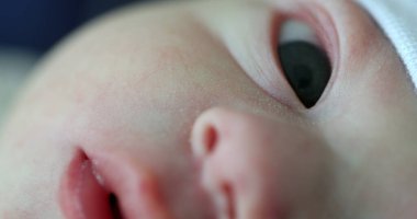Macro closeup of newborn face, baby infant eyes nose and mouth