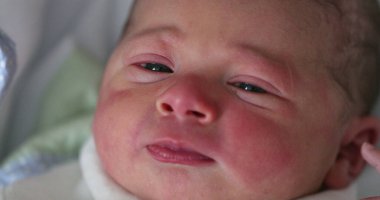 Newborn waking up opening eyes in first day of life