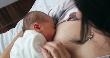 Newborn baby breastfeeding after birth, first day of life