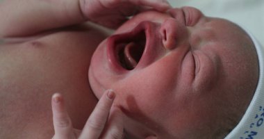 Newborn baby crying at hospital, first minutes of life