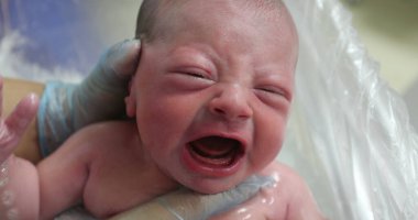 Newborn baby crying taking bath