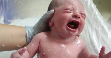 Newborn baby crying taking bath