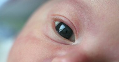Newborn baby macro eye in first day of life observing and learning about the world