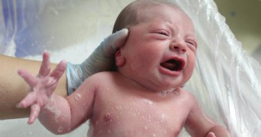 Newborn baby crying taking bath