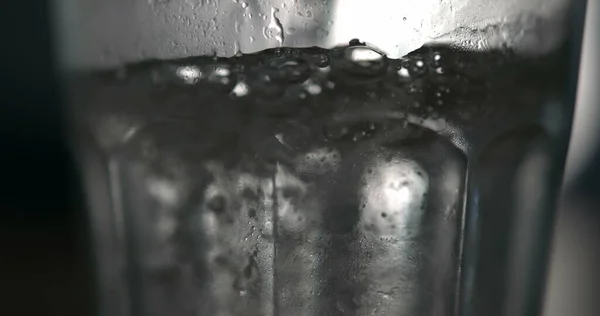 Bubbling Water Sprinkling onto Surface in Super Slow-Motion, Pouring refreshing drink into transparent glass cup