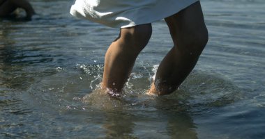 Çocuk bacakları süper yavaş çekimde zıplıyor. Su dalgaları ile 800 fps, küçük bir kız yukarı sıçrıyor. Yakalandı, doğayla temas kuruldu.