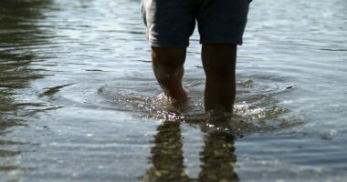 Göl kıyısında yürüyen çocuk ayakları