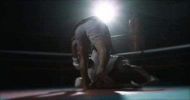 Rakibi yenen dövüşçü, 800 Fps 'lik yüksek hız rampasında dramatik ışıklandırmayla onu yere yapıştırıyor. İç halka boksörleri