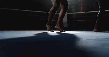 Avcı bacaklarının ve ayaklarının yakın plan görüntüleri halkanın içinde duruyor ve dramatik ışık yavaş çekimde yakalanıyor.