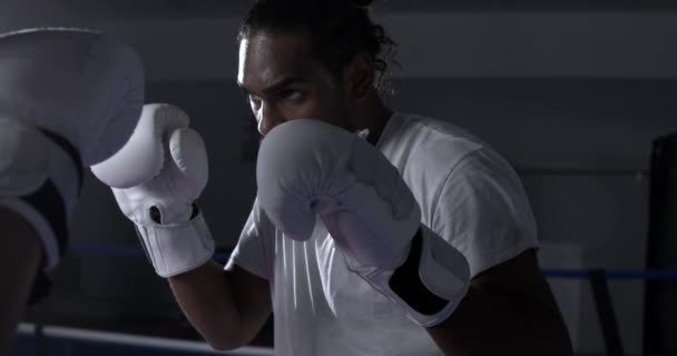 一个戴着拳击手套的年轻黑人拳击手用锐利的目光凝视着他的对手准备战斗 — 图库视频影像