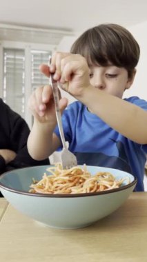 Genç Çocuk, Çatalla Makarna Döndürerek ve Yiyerek Motor Yetenekleri ve Bağımsızlığı Geliştiriyor