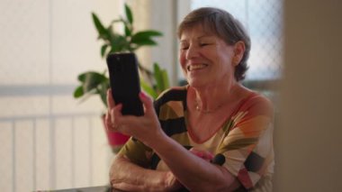 Modern Teknoloji Kullanarak Aile Üyeleriyle Video İletişimi kuran Kıdemli Bir Kadının Dijital Bağlantıları Sahnesi