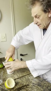 Son sınıf öğrencisi sabah yemeği için portakal sıkıyor.