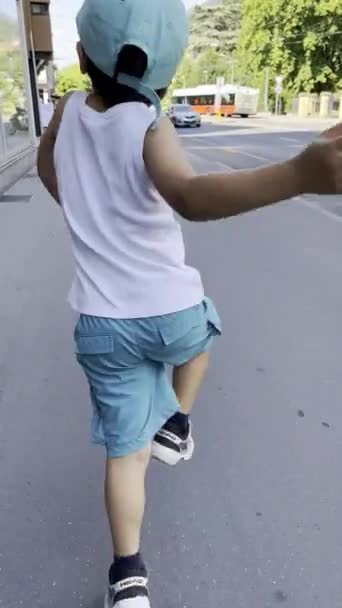 Ein Begeisterter Kleiner Junge Hüpft Fröhlich Über Den Bürgersteig Und — Stockvideo