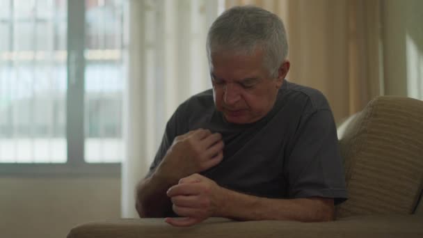 专心致志的老年人在家中做十字标志 年长的白人男子在沙发上祈祷 象征着精神和希望 — 图库视频影像