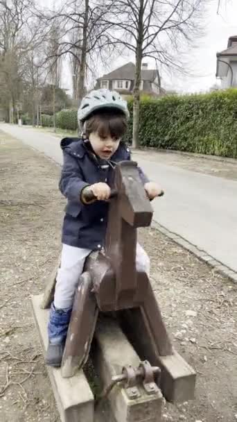 Boldog Gyerek Szórakozás Egy Public Wooden Horse Toy Sidewalk Egy — Stock videók