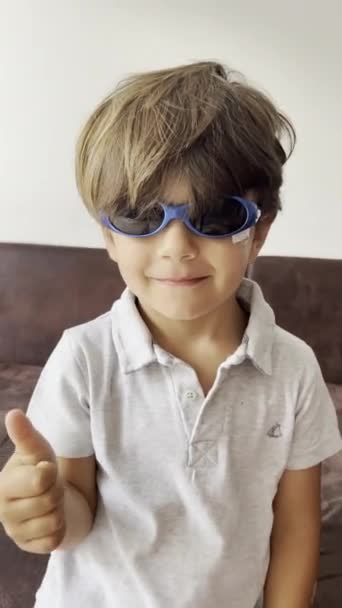 Youngster Mit Sonnenbrille Und Gesichtsverband Posiert Fällt Dann Zurück Auf — Stockvideo