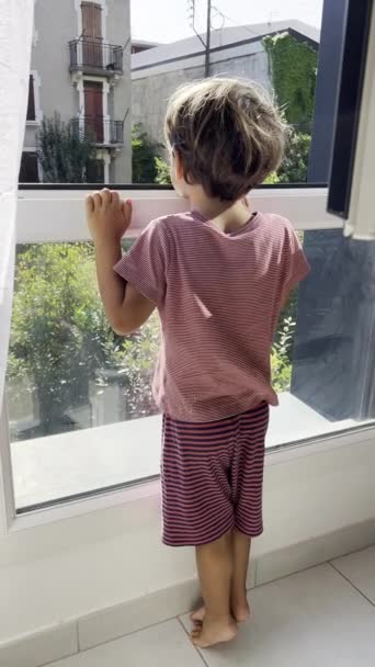 Niño Curioso Pijama Mirando Través Ventana Para Espiar Vecindario — Vídeos de Stock