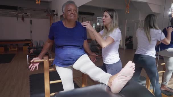 Black Senior Woman Stretching Body Pilates Coach Instruction Engaging Physiotherapy — Stock Video