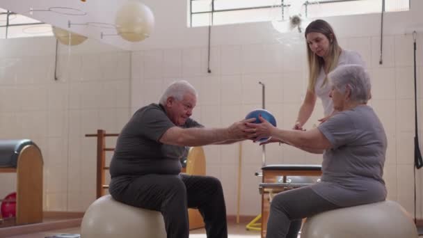Ηλικιωμένο Ζευγάρι Γυμνάζεται Μαζί Βοήθεια Ενός Γυναικείου Προπονητή Pilates Κατά — Αρχείο Βίντεο