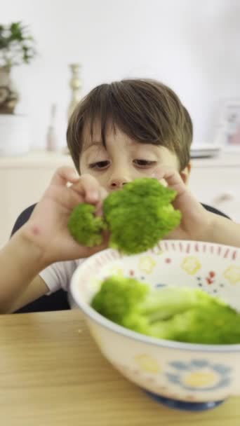 遊び心のある子供は 手で食べながらブロッコリーを落とし それを取得します — ストック動画