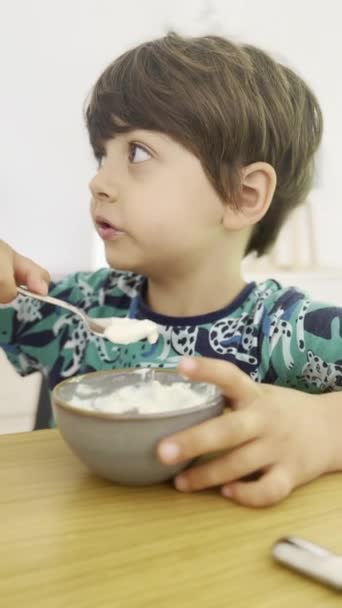 Время Завтрака Мальчик Наслаждается Йогуртом Следит Своим Окружением — стоковое видео