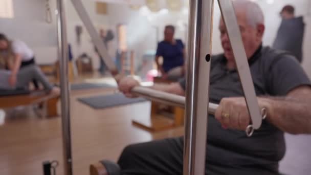 Starszy Mężczyzna Ćwiczący Pilates Machine Rutyna Treningu Starości Ćwiczenia Zdrowotne — Wideo stockowe