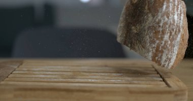 Düşen geleneksel kır ekmeği havada uçuşan un ve kırıntılarla kameraya yakalanır.