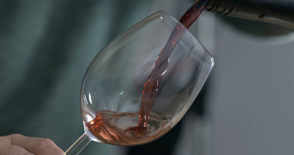Wine serving captured with camera. Pouring drink into glass