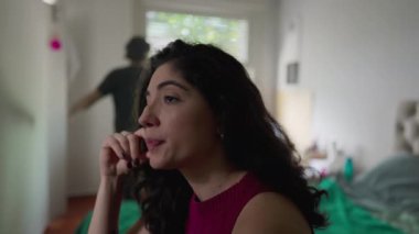 Kriz geçiren bir çift: Genç bir kadın, arka planda erkek partnerinin kırık ilişki hakkında çığlıklarını dinliyor.