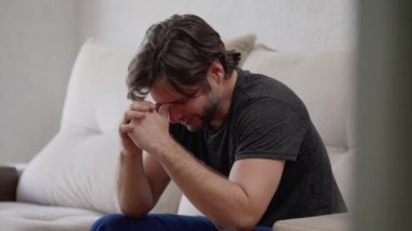 Geçmiş için pişmanlık duyan endişeli bir genç adam. 30 'lu yaşlarda bir erkek evde hüzün ve duygusal acıdan muzdarip.