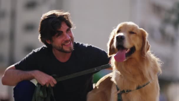 オス犬の飼い主がゴールデン レトリバーにペットを飼っている 30代の男はペット仲間と笑顔で — ストック動画