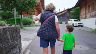 Torun, büyükannesiyle el ele yürüyor, Aile Bağları Hafta sonu Avrupa 'da küçük bir kasabada gezinti yapıyor.