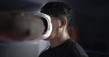 800 fps hızında süper dramatik ağır çekimde yüzüne yumruk yiyen bir adam havada ter damlacıkları uçuşuyor. Dövüşçü vuruldu.