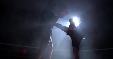 Dövüşçüler ringin içinde karşı karşıya gelir, boksörler Muay Thai yemeklerini yiyerek rakibinin vücuduna vurur. Yüksek hızlı kamerayla ağır çekimde dramatik arka plan ışığı