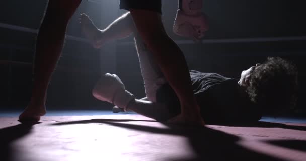 敗北した戦闘機は スーパースローモーションで地面に落ちる 劇的な照明とのボクシングの試合の間に男を床に投げるライバル — ストック動画
