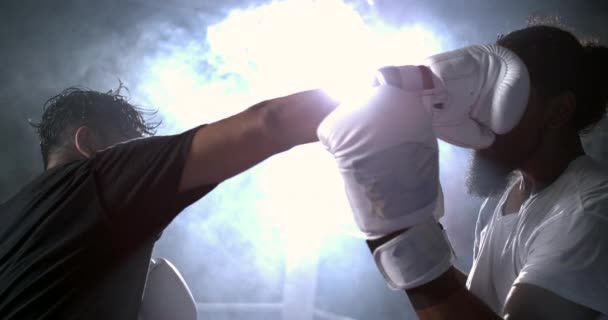 ボクシングリング内の劇的な照明で800 Fpsでスーパースローモーションで顔に相手を打つファイター ライバルパンチ 影響をキャプチャする男 — ストック動画