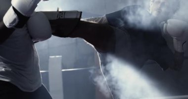 Dövüşçü, 800 fps dumanlı ve dumanlı ağır çekimde ve dramatik bir dövüşte rakibini yere seriyor.