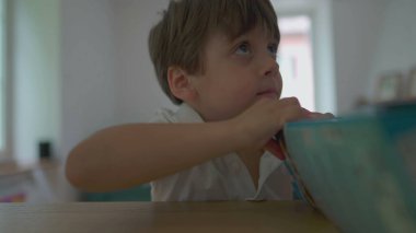 Küçük çocuk hevesle oyuncak kutusunu yırtıyor, hediyesini yırtıyor