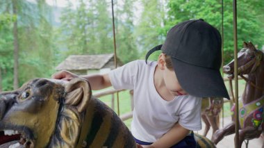 Yaz Parkı 'nda Atlıkarınca' da oturan neşeli küçük çocuk.