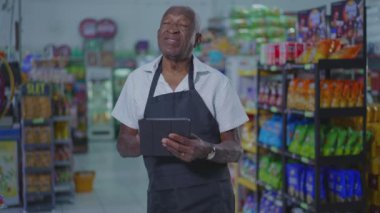 Kıdemli Afro-Amerikan Süpermarket Çalışanı Tablet Bilgisayarını Kullanıyor, İşyeri Teknolojisini Kullanmakta Zorlanıyor