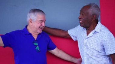 Afrikalı kıdemli adam ve eski dostlar gülüyor ve sarılıyorlar. 