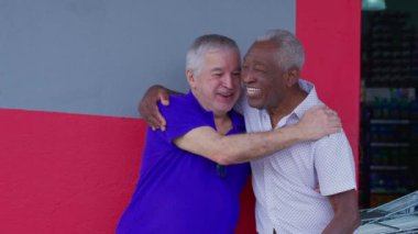 Afrikalı kıdemli adam ve eski dostlar gülüyor ve sarılıyorlar. 