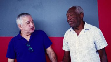 Afrikalı kıdemli adam ve eski dostlar gülüyor ve konuşuyor. 