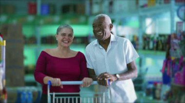Mutlu son sınıf öğrencisi ve alışveriş arabalı Afrikalı son sınıf öğrencisi.