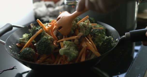 用热锅搅拌黑芝麻食品 用勺子把小手准备盘子 — 图库视频影像